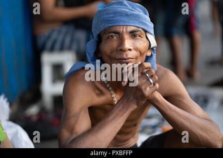 Un homme de son pays pose pour un portrait sur un trottoir à l'intérieur de la ville de Cebu, Philippines Banque D'Images