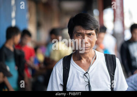 L'expression grave sur un Philippin mans visage alors qu'il pose pour une photo. Banque D'Images