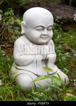 Petite statue de Bouddha d'un séjour dans un jardin Banque D'Images