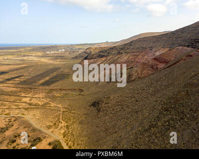 Vue aérienne de la côte montagneuse de l'île de Lanzarote, îles Canaries, Espagne. L'Afrique. Reliefs donnant sur la mer et la poussière des chemins. Banque D'Images