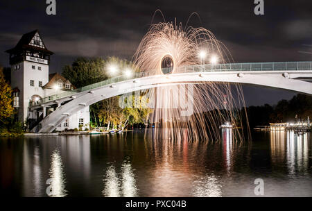 Berlin, Allemagne. 20 Oct, 2018. Un homme se tient sur le pont de l'île de la jeunesse et crée un cercle de feu dans le ciel du soir. Crédit : Paul Zinken/dpa/Alamy Live News Banque D'Images