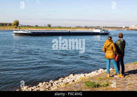 Duisburg, Allemagne. 21 octobre 2018. Les gens regardent un navire de marchandises sur le Rhin. En ce moment, les navires ne sont en mesure de transporter environ un tiers de la charge normale. Historiquement faibles niveaux d'eau, exposer le lit de la rivière du Rhin à Ruhrort, le port de Duisburg. Le faible niveau de l'eau causent des problèmes pour le transport et l'on s'attend à aggraver la sécheresse persiste. Photo : 51Nord/Alamy Crédit : 51Nord/Alamy Live News Banque D'Images