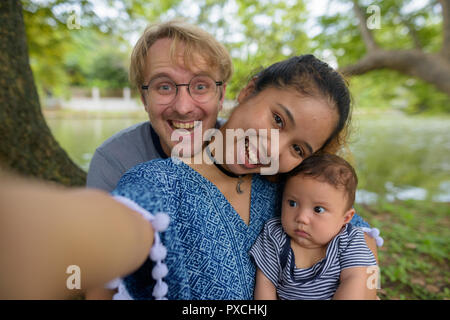 Jeune famille multi-ethnique liens affectifs au le parc Banque D'Images