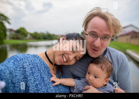 Jeune famille multi-ethnique liens affectifs au le parc Banque D'Images