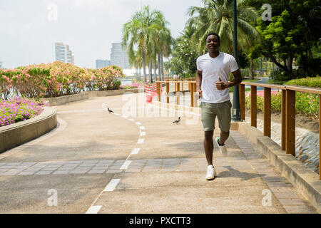 Jeune homme africain en marche en plein air dans le parc Banque D'Images