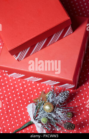 Cadeaux de Noël et des rameaux d'arbre de Noël sur un papier d'emballage rouge Banque D'Images