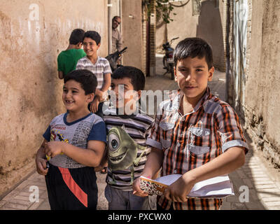 YAZD, IRAN - le 18 août 2015 : Groupe d'élèves de l'Iran, les garçons, les élèves des écoles primaires et secondaires, debout et jouer , l'un tenant une étude noteboo Banque D'Images