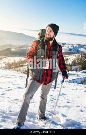 Homme barbu randonneur sur une montagne enneigée. Randonnée d'hiver Banque D'Images