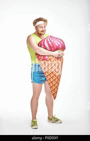 Aux cheveux rouges, barbu, joufflu l'homme est maintenant un grand ice cream Banque D'Images