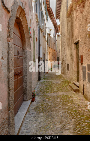 Paysage urbain de maisons anciennes à l'aide de petits massifs alley historique au village touristique sur le lac de Como, tourné en automne lumineux lumière à San Siro, Italie Banque D'Images