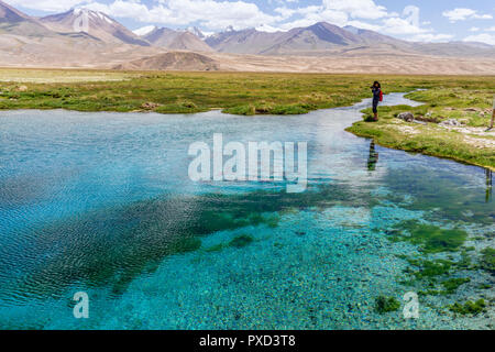 Photographe à Ak-Balik est une source sacrée avec l'eau bleu clair situé le long de la route du Pamir non loin de Alichur, Pamir, Gorno-Badakhs Banque D'Images