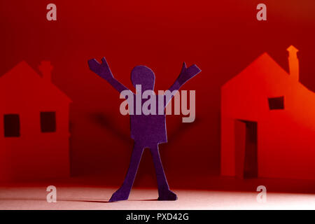 Papier coupé d'une personne sur l'arrière-plan des maisons. Banque D'Images