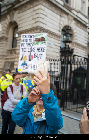 Un manifestant tient une pancarte de protestation en face de Downing Street, en tant que quelqu'un prend avec elle pendant l'selfies vote du peuple de mars. Banque D'Images