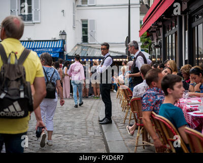 Paris, France - 12 août 2018 : un serveur en attente d'une clientèle à l'extérieur traditionnel café parisien à Montmartre. Banque D'Images