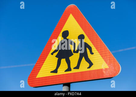 Panneau de passage à niveau de l'école, rouge, jaune et noir, contre un ciel bleu ; la Suède Banque D'Images