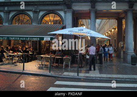 Vue nocturne d'un café élégant - restaurant, et une belle arcade commerciale à arcades du début du siècle. La ville de Bruxelles en Belgique. Banque D'Images