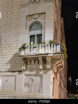 Balcon fleuri à l'angle de l'hôtel de ville de la ville de Zadar avec des exemples de reliefs sous Banque D'Images