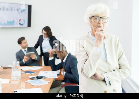 Pensive senior female business executive en salle du conseil d'administration Banque D'Images