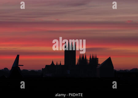 Stripey rose nuages à l'aube sur la cathédrale de Canterbury en octobre. Silhouette de la cathédrale de Canterbury et divers toits et un the maltings. Banque D'Images