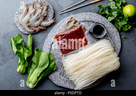 La cuisine asiatique Ingrédients : Riz nouilles, pok choy, les sauces, les crevettes crues. Concept Cuisine asiatique Cuisine thaïlandaise ou chinoise. Banque D'Images