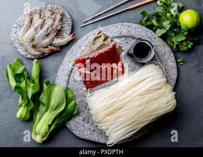 La cuisine asiatique Ingrédients : Riz nouilles, pok choy, les sauces, les crevettes crues. Concept Cuisine asiatique Cuisine thaïlandaise ou chinoise. Banque D'Images