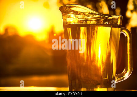 Pichet d'eau fraîche tir contre la lumière sur un beau coucher du soleil. Banque D'Images