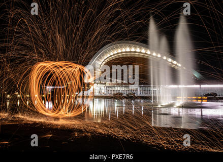 Berlin, Allemagne. 21 Oct, 2018. Un homme appelle spirale dans le ciel nocturne avec le feu en face de la Maison des Cultures du Monde. (Longue exposition) Crédit : Paul Zinken/dpa/Alamy Live News Banque D'Images