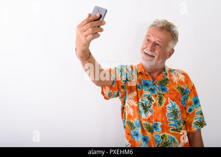 Studio shot of happy senior man smiling touristiques barbu alors que ta Banque D'Images