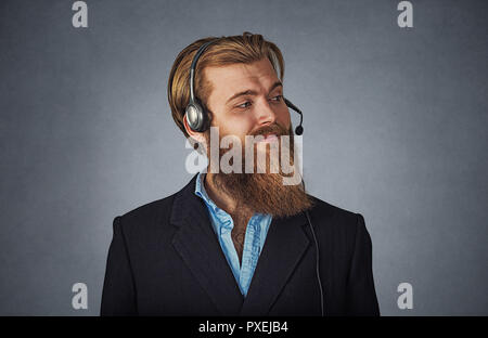 Profil latéral portrait of smiling customer service representative smiling. Hipster barbu dans l'homme d'affaires gris casque isolé sur gre Banque D'Images