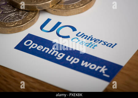 Un morceau de papier avec le logo crédit universel, repose sur une table avec quelques pièces de 1 €. Banque D'Images
