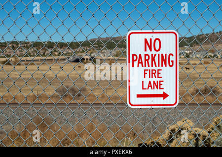 Aucun stationnement fire lane signe sur une clôture en stationnement Banque D'Images