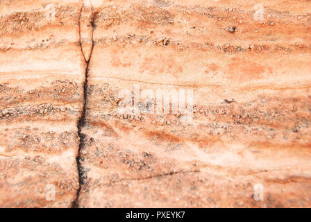 Libre d'une lumière orange/rouge/blanc mur de pierre avec des fissures et des lignes en elle, dans le désert près du lac Meredith, Texas, États-Unis Banque D'Images