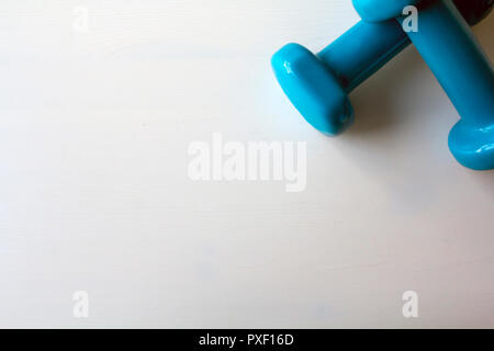 Deux haltères en bleu sur fond blanc Banque D'Images