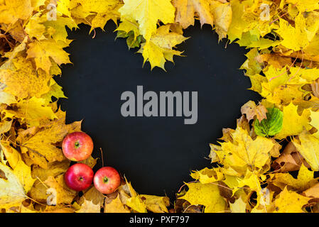 Tableau noir avec cadre de feuilles en forme de coeur. Cadre est vide. Avec des pommes Banque D'Images