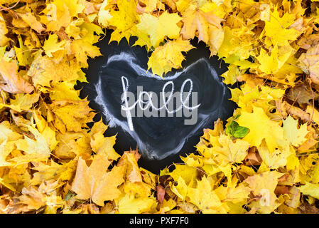 Tableau noir avec cadre de feuilles en forme de coeur. L'automne est écrit là Word Banque D'Images