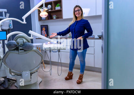 Vue depuis la porte d'entrée du dentiste qui reçoit le patient dans le bureau avec la chaise du dentiste Banque D'Images