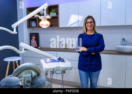 Portrait de femme dentiste smiling in dental office habillé de bleu uniforme médical Banque D'Images
