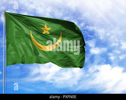 Drapeau national de la Mauritanie sur un poteau en face de ciel bleu. Banque D'Images