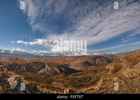 Paysage d'automne avec une étonnante rivière sinueuse, forêt, arbres d'or, route asphaltée et les montagnes couvertes de neige contre un ciel bleu et nuages Banque D'Images