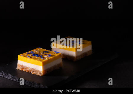 Gâteau à la mangue et citron vert fait maison sur une plaque en pierre noire Banque D'Images