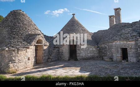 Groupe d'conique traditionnelle blanchie à la maisons à toit plat dans la ville de Alberobello dans les Pouilles, Italie du Sud. Banque D'Images