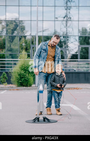 Heureux père et petit fils de lancer une fusée modèle Banque D'Images