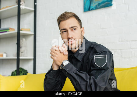 Young policier assis sur table jaune Banque D'Images