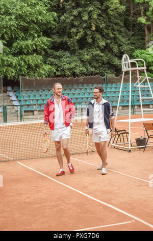 Vieux-fashionedfriends avec raquettes en bois sur pied court de tennis Banque D'Images