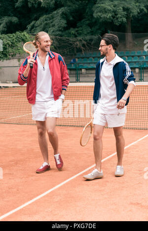 Joyeux amis sportifs avec des raquettes de tennis sur marche Banque D'Images