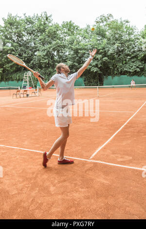 Athletic hommes jouer au tennis avec des raquettes en bois rétro sur cour Banque D'Images