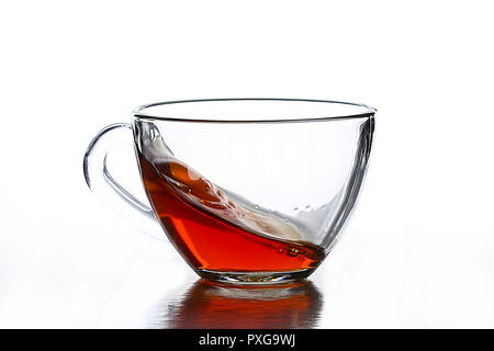 Une touche de thé dans une tasse de thé en verre sur un fond blanc Banque D'Images