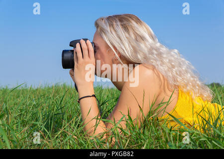 Jeune blonde hollandaise de photographies en prairie avec ciel bleu Banque D'Images