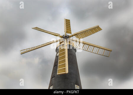 Moulin à vent britannique isolé à six voiles depuis un point de vue à angle bas. Vue à œil nu, vue d'en haut des pales du moulin à vent, avec un ciel nuageux spectaculaire. Banque D'Images