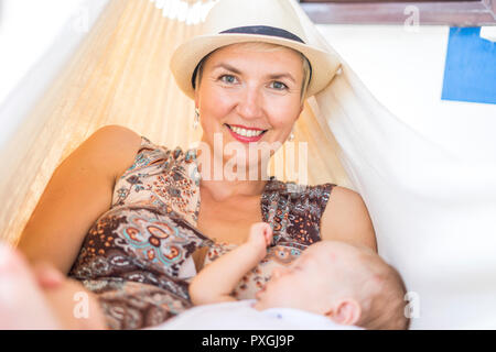 Mère et son petit baby boy relaxing in hammock en face de la maison Banque D'Images